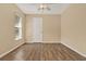 This bedroom features wood-look tile floors, a window, and a white door at 208 Lake Region S Blvd, Winter Haven, FL 33881