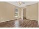 This bedroom features wood floors, a window, and an entry to the walk-in closet at 208 Lake Region S Blvd, Winter Haven, FL 33881