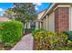 Close-up of front brick and stucco exterior, with manicured shrubbery and brick pathway at 208 Lake Region S Blvd, Winter Haven, FL 33881