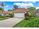 Beautiful home with manicured lawn and garden, featuring a tile roof and two-car garage at 208 Lake Region S Blvd, Winter Haven, FL 33881