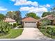 Landscaped single-story home with a tile roof, featuring a lush lawn and a spacious two-car garage at 208 Lake Region S Blvd, Winter Haven, FL 33881