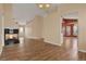 Spacious living room featuring wood floors, fireplace, neutral walls, and access to the dining room at 208 Lake Region S Blvd, Winter Haven, FL 33881
