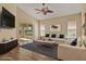 Bright living room featuring wood floors, neutral walls, and a ceiling fan with slider doors leading to a sunroom at 208 Lake Region S Blvd, Winter Haven, FL 33881