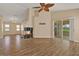 Spacious living room with tile floors, fireplace, ceiling fan, and sliding glass doors to lanai at 208 Lake Region S Blvd, Winter Haven, FL 33881