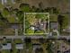 Aerial view showing the house with some overgrown greenery requiring major repairs at 215 10Th Wahneta W St, Winter Haven, FL 33880