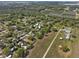 An expansive aerial view displays a community with homes surrounded by mature trees and agricultural land, creating a tranquil ambiance at 215 10Th Wahneta W St, Winter Haven, FL 33880