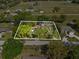 Aerial view showing the house with some overgrown greenery requiring major repairs at 215 10Th Wahneta W St, Winter Haven, FL 33880