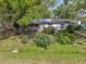 Overgrown yard with small house and screen porch needing repair at 215 10Th Wahneta W St, Winter Haven, FL 33880