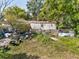 Exterior shows a home needing extensive repairs and overgrown landscaping at 215 10Th Wahneta W St, Winter Haven, FL 33880