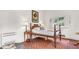 Bedroom featuring brick floors, a wood-frame bed, vintage furnishings, and natural light at 2300 N Scenic Hwy # 56, Lake Wales, FL 33898