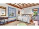 This bedroom features wood floors, beamed ceilings, and a large window overlooking the backyard at 2300 N Scenic Hwy # 56, Lake Wales, FL 33898