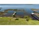 Expansive waterfront backyard featuring mature palms, lush lawn, and tranquil lake views at 2350 Crump Rd, Winter Haven, FL 33881
