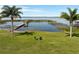 Chairs in the backyard on the lawn by the lake and dock at 2350 Crump Rd, Winter Haven, FL 33881
