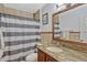 Bathroom featuring a wood vanity with stone countertop, mirror, and shower with striped curtain at 2350 Crump Rd, Winter Haven, FL 33881