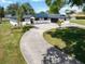 Charming single-story home boasts a modern aesthetic, long driveway, and lush lawn at 2350 Crump Rd, Winter Haven, FL 33881