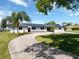 Charming single-story home featuring a long driveway, well-manicured lawn, solar panels and inviting front porch at 2350 Crump Rd, Winter Haven, FL 33881