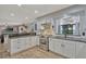 Bright kitchen with white cabinets, dark countertops, stainless steel appliances, and an adjacent sunroom at 2350 Crump Rd, Winter Haven, FL 33881