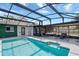 In-ground screened pool area with patio seating and a water view at 2350 Crump Rd, Winter Haven, FL 33881