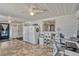 Sunroom with tile flooring, white walls, two refrigerators and access to the kitchen at 2350 Crump Rd, Winter Haven, FL 33881