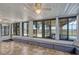 Enclosed sunroom featuring tile floor, multiple sliding glass windows, and bench seating along the perimeter at 2350 Crump Rd, Winter Haven, FL 33881