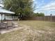 Backyard featuring a patio area with table and chairs and mature trees at 253 Walter Ave, Frostproof, FL 33843