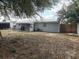 A spacious backyard featuring a patio area, privacy fence, and mature trees at 253 Walter Ave, Frostproof, FL 33843