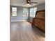 Sunlit bedroom with updated ceiling fan and dark laminate flooring at 253 Walter Ave, Frostproof, FL 33843