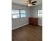Bedroom with hardwood floors, dresser, and two windows at 253 Walter Ave, Frostproof, FL 33843