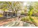 Backyard with shed, screened lanai and stone benches under mature trees at 3027 Maplewood Ave, Lakeland, FL 33803