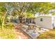 Exterior of the home with an outdoor dining area and large shade tree at 3027 Maplewood Ave, Lakeland, FL 33803