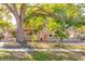 Exterior of the home featuring a decorative stone facade and mature shade tree at 3027 Maplewood Ave, Lakeland, FL 33803