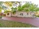Charming single-story home featuring a stone facade, mature trees, and a spacious driveway at 3027 Maplewood Ave, Lakeland, FL 33803