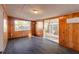 Bright living room with wood paneled walls, large windows, and access to an outdoor patio at 3027 Maplewood Ave, Lakeland, FL 33803