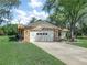 Exterior of a single story home featuring a brick facade, attached garage, and well-maintained landscaping at 3471 Black Jack Ct, Lake Wales, FL 33898