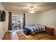 A bedroom with a sliding glass door to the balcony and wood-style floors and a ceiling fan at 398 Winter Ridge Blvd # 398, Winter Haven, FL 33881