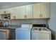 A laundry room area in a kitchen is equipped with a washer, dryer, and stainless steel dishwasher at 398 Winter Ridge Blvd # 398, Winter Haven, FL 33881