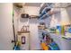 Organized storage area with shelves, cleaning supplies, and water heater inside the home at 398 Winter Ridge Blvd # 398, Winter Haven, FL 33881