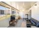 Bright sunroom featuring a large window view, ceiling fan, dark leather sofa, and exercise equipment at 398 Winter Ridge Blvd # 398, Winter Haven, FL 33881