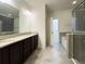 Bathroom featuring double vanity, granite countertops, tiled flooring, and glass enclosed shower at 4004 Prima Lago Cir, Lakeland, FL 33810