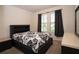 Comfortable bedroom featuring a stylish black headboard bed, carpet floors, and natural light from the windows at 4004 Prima Lago Cir, Lakeland, FL 33810