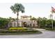 Beautiful clubhouse entrance with meticulous landscaping and mature palm trees at 4004 Prima Lago Cir, Lakeland, FL 33810