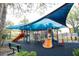 Community playground with climbing structures and slides under a shade canopy at 4004 Prima Lago Cir, Lakeland, FL 33810