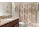 Well-lit bathroom featuring granite counters, shower with themed curtain, and toilet at 4009 Bedford Ave, Winter Haven, FL 33884