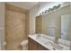 Well-lit bathroom featuring double sinks, a neutral tile shower, and contemporary fixtures at 404 Laurel Cove Way # 404, Winter Haven, FL 33884
