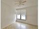 Bedroom with tan tile floor, ceiling fan, and window with blinds at 404 Laurel Cove Way # 404, Winter Haven, FL 33884