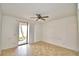 Bright bedroom with ceiling fan, sliding glass door to balcony and neutral tile flooring at 404 Laurel Cove Way # 404, Winter Haven, FL 33884