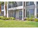 Exterior view of condo featuring a screened patio, lush landscaping and well-maintained lawn at 404 Laurel Cove Way # 404, Winter Haven, FL 33884