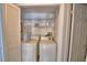 Laundry room features a washer and dryer with wire shelving above, enclosed by paneled doors at 404 Laurel Cove Way # 404, Winter Haven, FL 33884