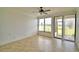 Cozy living room with tiled floor, ceiling fan, and screened porch entrance with natural light at 404 Laurel Cove Way # 404, Winter Haven, FL 33884