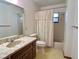 Bathroom with decorative vanity, mirror, and bathtub with shower and curtain at 407 Paradise Island Dr, Haines City, FL 33844